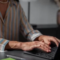 Pessoa digitando em um laptop moderno em um ambiente de trabalho, destacando a importância da produtividade e do foco no trabalho remoto.